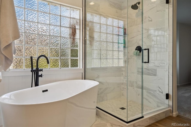 full bathroom featuring a stall shower and a freestanding bath
