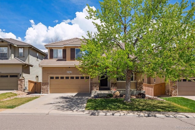view of front of property with stone siding, a garage, driveway, stucco siding, and a tile roof
