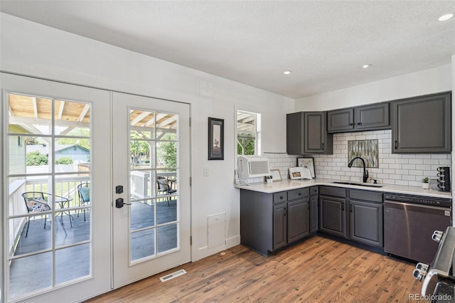 18355 W 59th Dr, Golden, CO 80403 - kitchen with stainless steel dishwasher, gray cabinets, tasteful backsplash, light wood finished floors, and light countertops