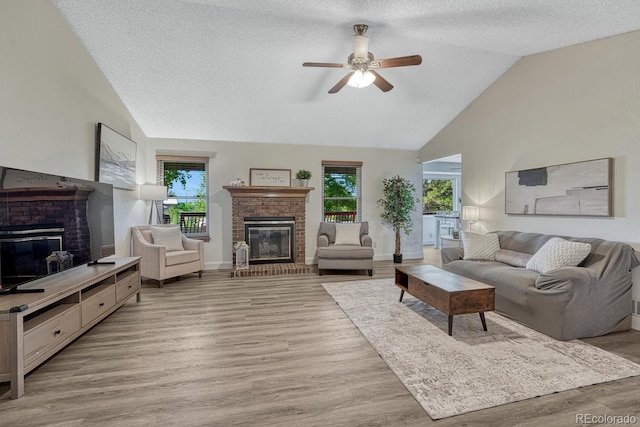 1572 W Long Ave, Littleton, CO 80120 - living area featuring a brick fireplace, a ceiling fan, light wood-type flooring, a textured ceiling, and high vaulted ceiling