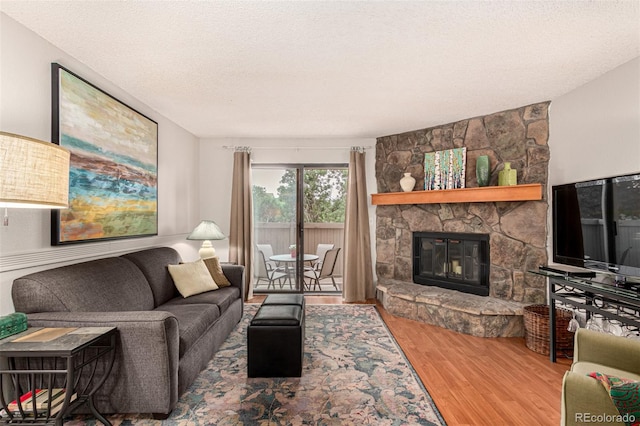 7750 W 87th Dr Unit C, Arvada, CO 80005 - living area featuring wood finished floors, a fireplace, and a textured ceiling