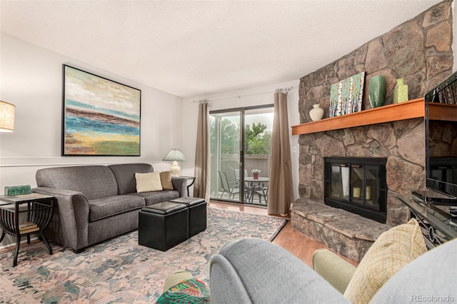 7750 W 87th Dr Unit C, Arvada, CO 80005 - living area with wood finished floors, a fireplace, and a textured ceiling