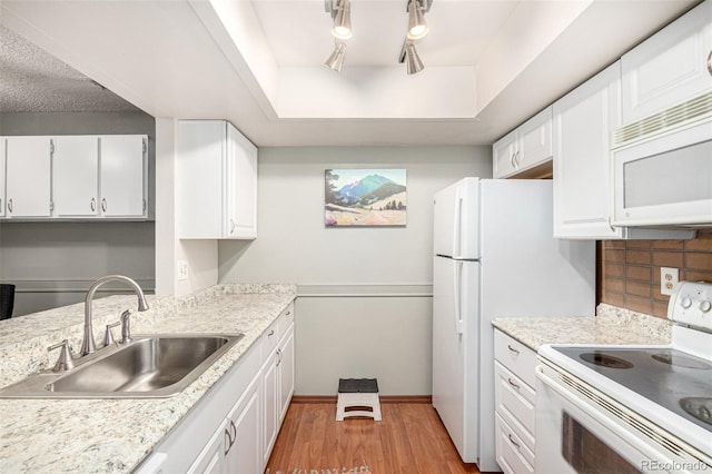 7750 W 87th Dr Unit C, Arvada, CO 80005 - kitchen with white appliances, light wood-type flooring, light countertops, white cabinetry, and decorative backsplash
