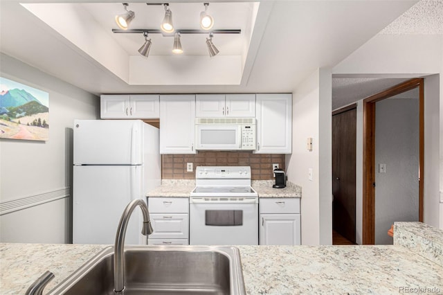 7750 W 87th Dr Unit C, Arvada, CO 80005 - kitchen featuring white appliances, white cabinetry, tasteful backsplash, and a raised ceiling