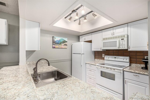 7750 W 87th Dr Unit C, Arvada, CO 80005 - kitchen with white appliances, a tray ceiling, white cabinetry, and light countertops