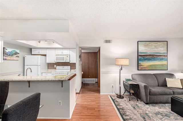 7750 W 87th Dr Unit C, Arvada, CO 80005 - living room with light wood-style flooring and a textured ceiling