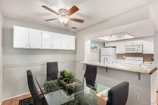 7750 W 87th Dr Unit C, Arvada, CO 80005 - dining room featuring wood finished floors, a textured ceiling, and a ceiling fan