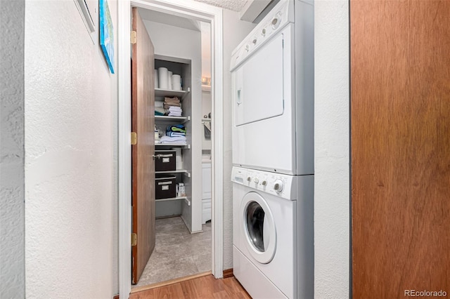 7750 W 87th Dr Unit C, Arvada, CO 80005 - washroom with stacked washer / drying machine, light wood-style flooring, and a textured wall