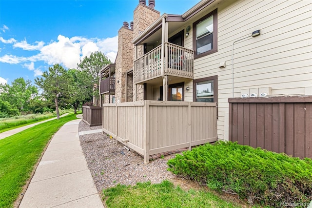 7750 W 87th Dr Unit C, Arvada, CO 80005 - view of home's exterior with a chimney and a balcony