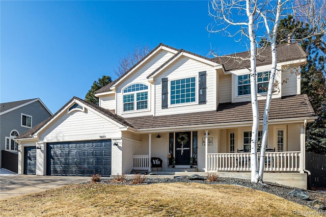 traditional-style house featuring driveway, brick siding, covered porch, and an attached garage