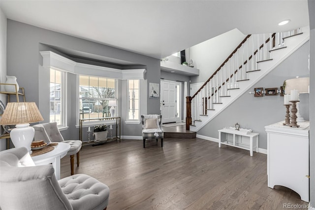 sitting room with stairs, wood finished floors, and baseboards