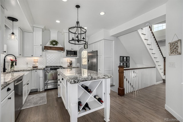 kitchen with light stone counters, custom exhaust hood, open shelves, a sink, and stainless steel appliances