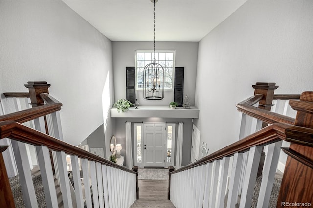 entrance foyer with wood finished floors, a chandelier, and stairs