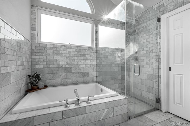 full bathroom featuring a garden tub, marble finish floor, and a stall shower