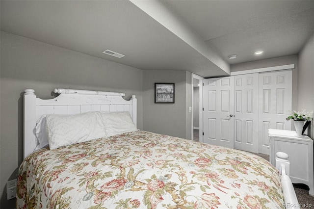 bedroom featuring a closet, visible vents, and carpet flooring