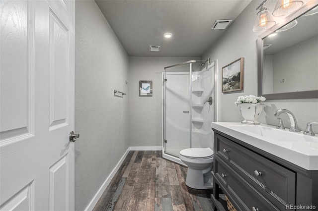 full bath featuring toilet, wood finished floors, visible vents, and a stall shower