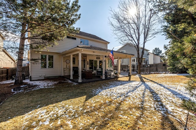 rear view of house with a fenced backyard and a patio area