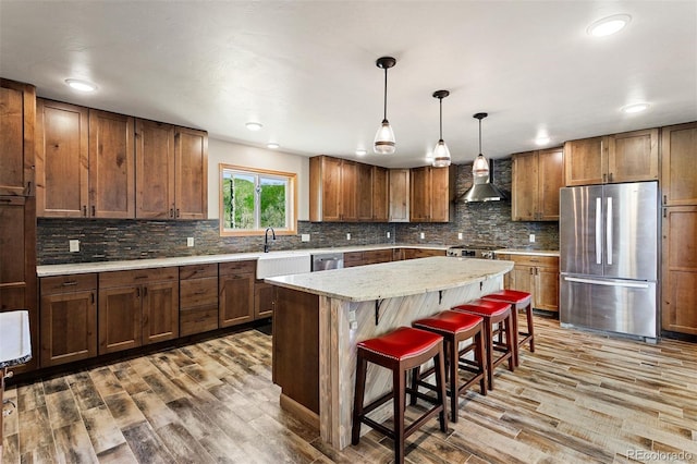 116 County Road 414, Granby, CO 80446 - kitchen with stainless steel appliances, wood finished floors, a breakfast bar area, tasteful backsplash, and a center island