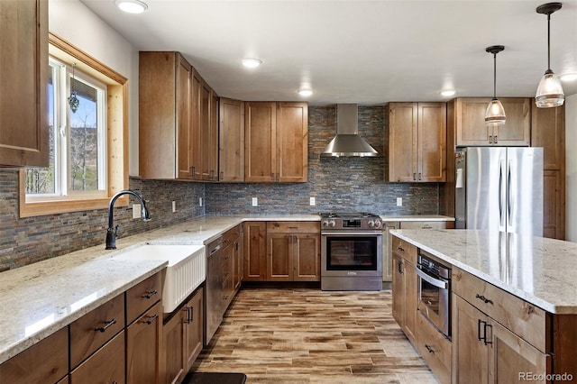 116 County Road 414, Granby, CO 80446 - kitchen with stainless steel appliances, wall chimney range hood, light wood-type flooring, and tasteful backsplash