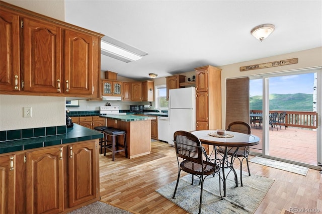 116 County Road 414, Granby, CO 80446 - kitchen featuring white appliances, brown cabinetry, light wood-type flooring, healthy amount of natural light, and vaulted ceiling