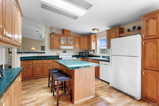 116 County Road 414, Granby, CO 80446 - kitchen with white appliances, light wood-type flooring, a breakfast bar, a center island, and brown cabinets