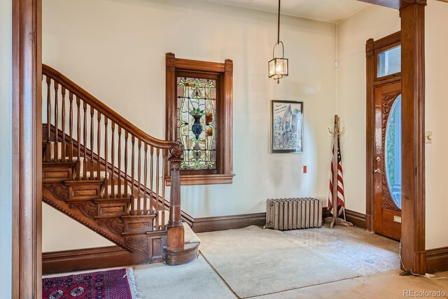 foyer entrance with a towering ceiling and radiator heating unit