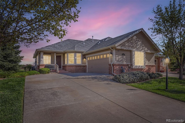 single story home featuring a porch, a front yard, a garage, brick siding, and concrete driveway