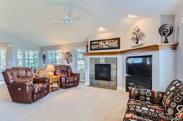 carpeted living room with a wealth of natural light, a fireplace, a ceiling fan, and lofted ceiling
