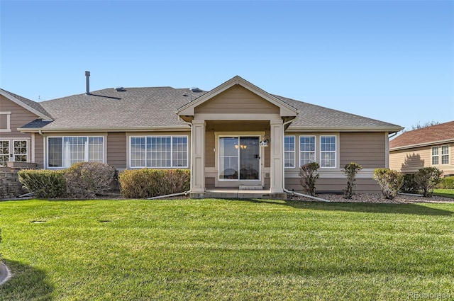 view of front of home with roof with shingles and a front lawn