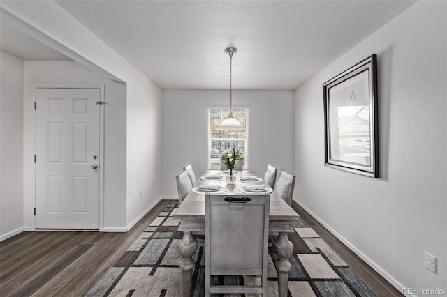 dining area with dark wood-type flooring and baseboards