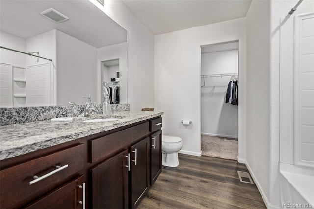 full bath with visible vents, wood finished floors, toilet, and vanity