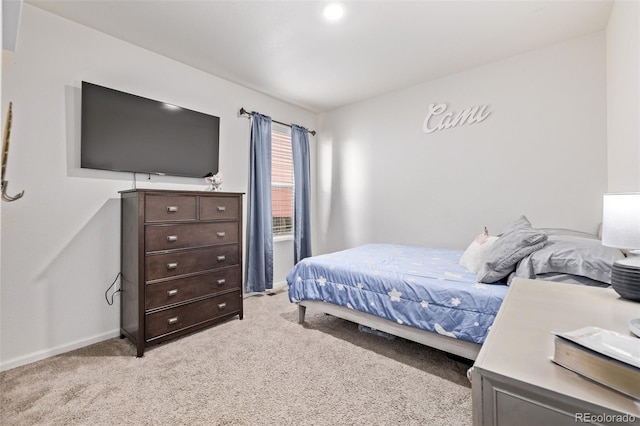 bedroom with baseboards and light carpet