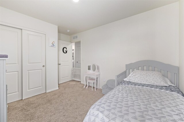 carpeted bedroom featuring a closet and visible vents