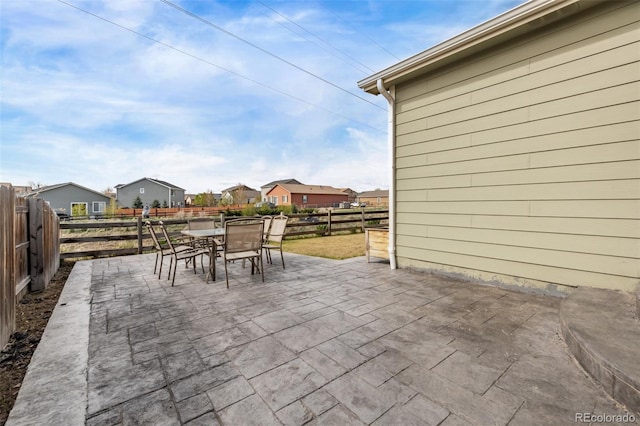 view of patio featuring a fenced backyard, a residential view, and outdoor dining space