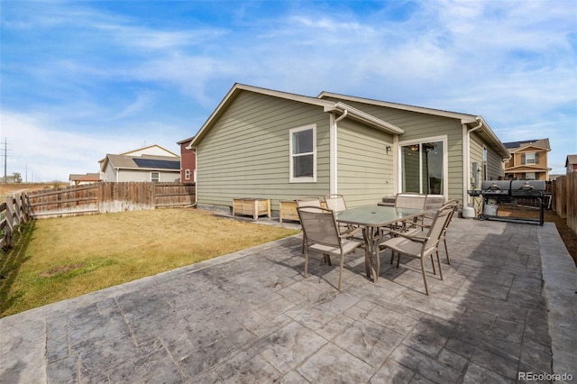 rear view of house with a patio, a fenced backyard, a yard, and outdoor dining space