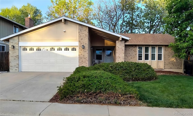 8908 Jellison Ct, Westminster, CO 80021 - view of front facade with driveway, an attached garage, brick siding, and a chimney
