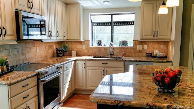 8908 Jellison Ct, Westminster, CO 80021 - kitchen featuring stainless steel appliances, a sink, light stone counters, decorative backsplash, and light wood-style flooring