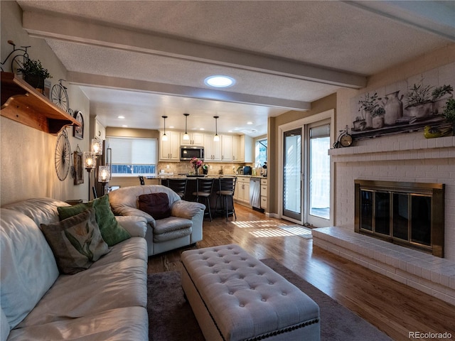 8908 Jellison Ct, Westminster, CO 80021 - living area with beam ceiling, a fireplace, wood finished floors, recessed lighting, and a textured ceiling