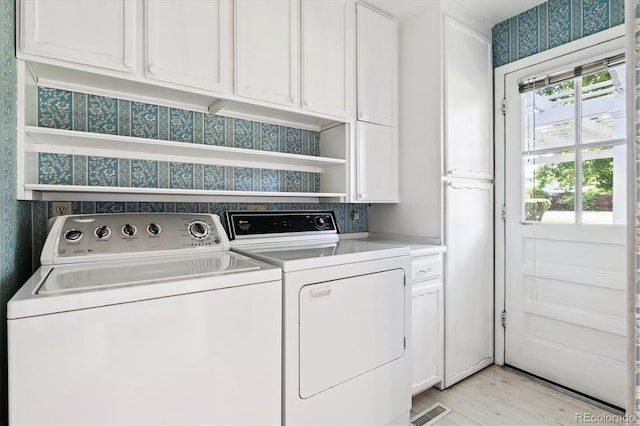 7129 S Marshall St, Littleton, CO 80128 - laundry room featuring cabinet space, washer and clothes dryer, light wood finished floors, and wallpapered walls
