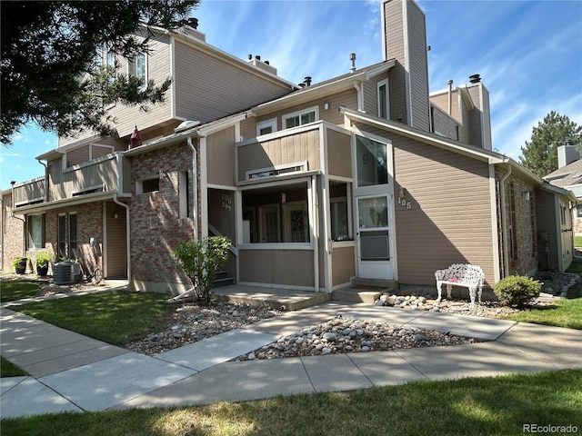 rear view of property featuring a balcony and central AC unit