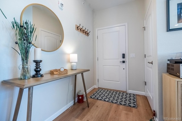 doorway to outside with baseboards and wood finished floors