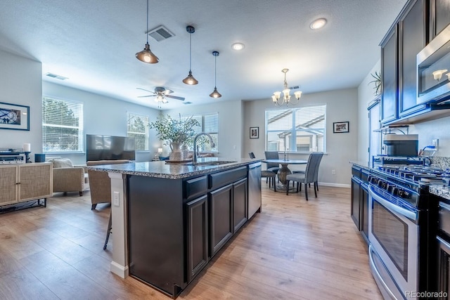 kitchen with light wood-type flooring, visible vents, appliances with stainless steel finishes, and a sink