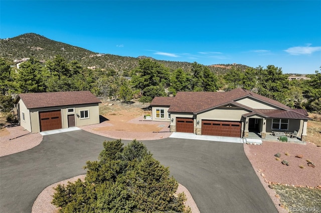 view of front of home featuring a garage, a mountain view, driveway, and stucco siding