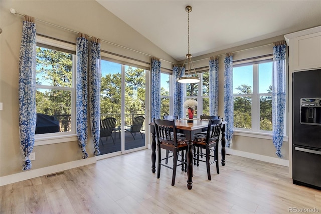 dining room featuring vaulted ceiling, baseboards, visible vents, and light wood finished floors