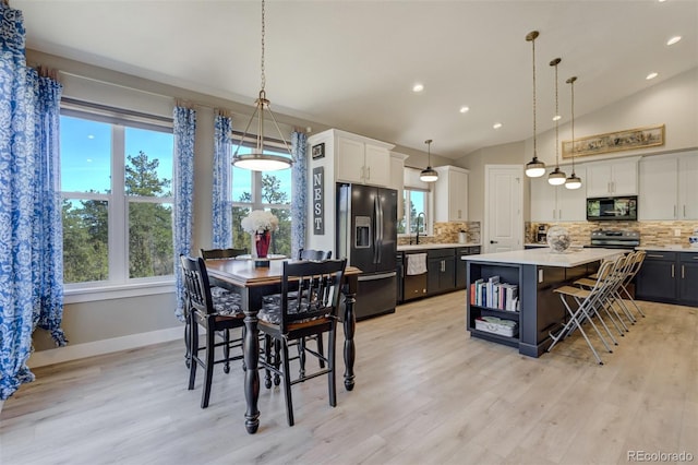 dining area featuring recessed lighting, baseboards, light wood-style floors, and vaulted ceiling