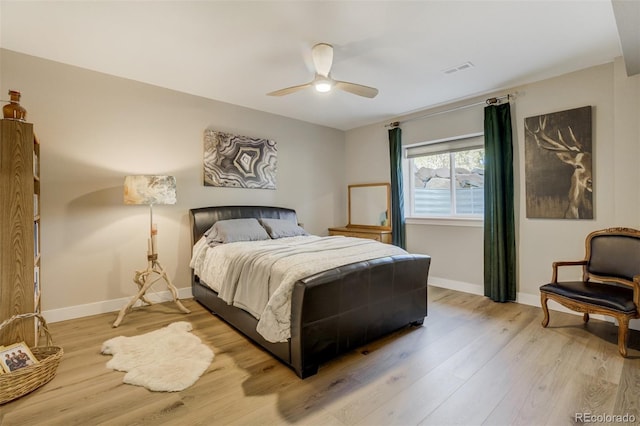 bedroom featuring light wood-style flooring, visible vents, baseboards, and ceiling fan