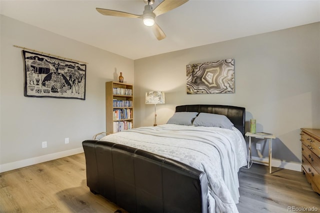 bedroom featuring a ceiling fan, baseboards, and wood finished floors