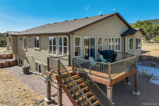 back of property with central air condition unit, stucco siding, and roof with shingles