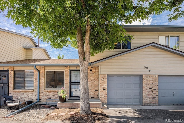 5210 Garrison St Unit 2, Arvada, CO 80002 - view of front of house with brick siding, an attached garage, and driveway