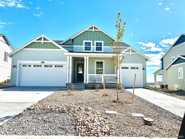 view of front of property with central air condition unit, a porch, and a garage